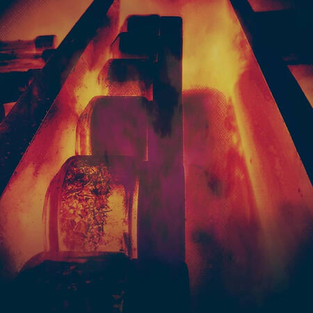 Furnace: A fiery, industrial scene with glowing reds and oranges and abstract machinery shapes, like molten cascades. Actually a sideways picture of a spice rack I took and edited.