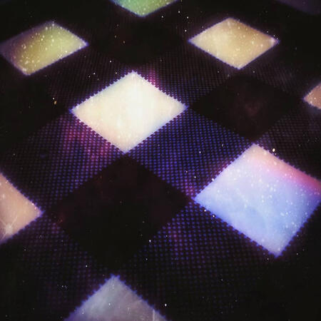 Tablecloth: Picture edit of a cosmic reinterpretation of a tablecloth, where squares glow with galaxy light across the check pattern. Originally a picture of a black-and-white checked tablecloth fabric, with crisp weave detail, taken at a pizza restaurant